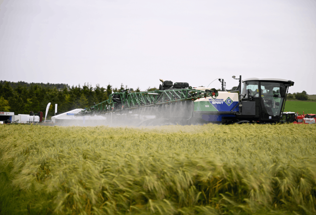 Agricultural sprayer applying fertiliser to a growing crop, highlighting the importance of planning liquid fertiliser storage early for the 2027 farming season.