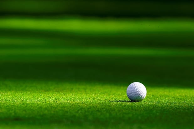 A golf ball on a clean golf course to show how water sustainability helps reduce their environmental footprint.